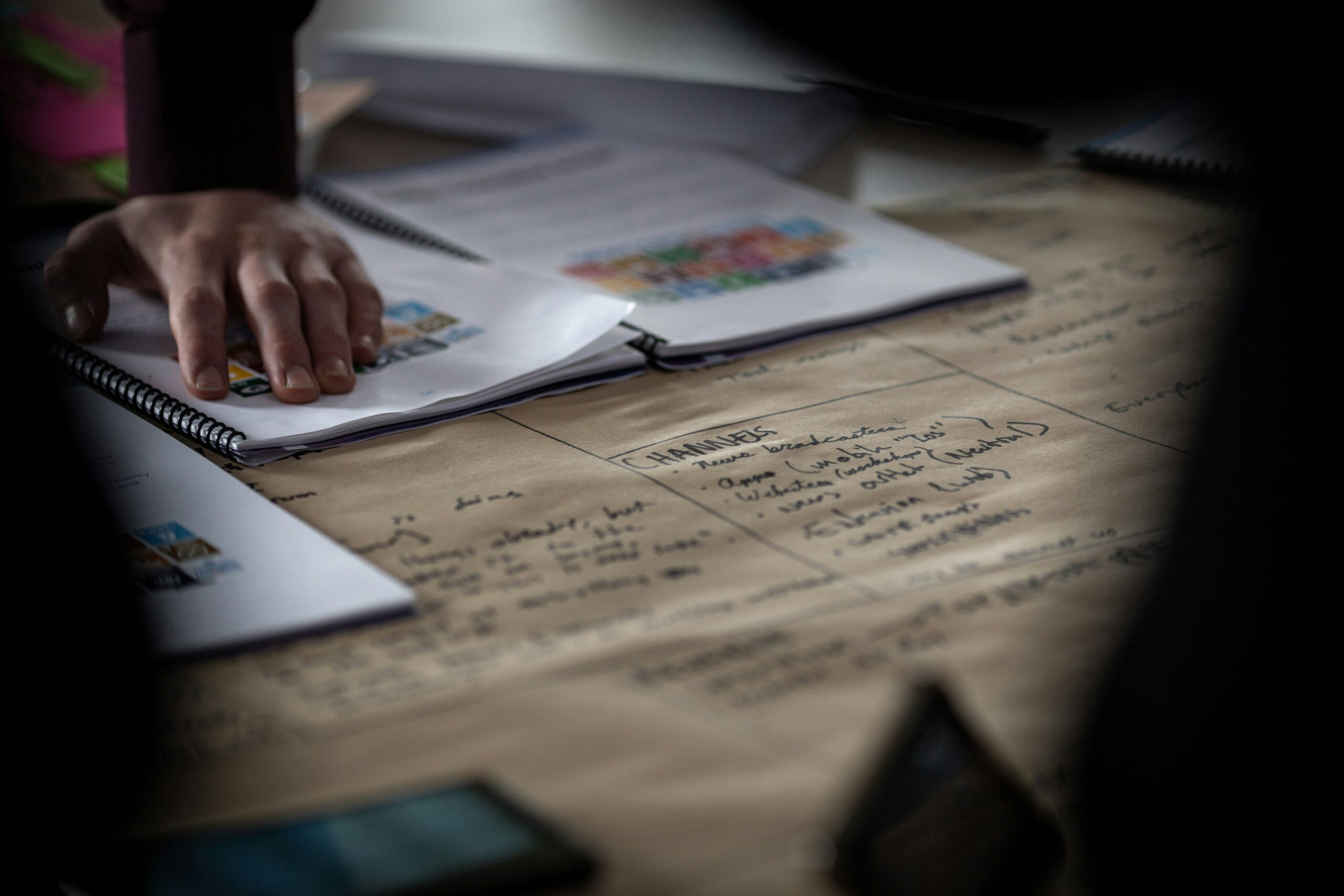 A person writing notes in a notebook, representing how to prepare for a career fair with a practical checklist